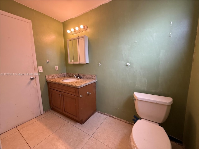 bathroom with toilet, tile patterned flooring, and vanity