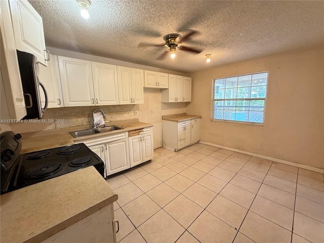 kitchen featuring white cabinetry, electric range, stainless steel microwave, and a sink