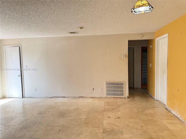 spare room featuring visible vents and a textured ceiling