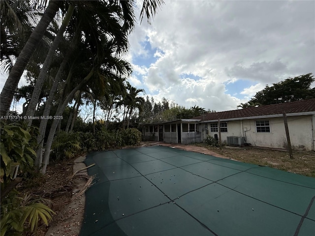 view of pool with cooling unit and a covered pool