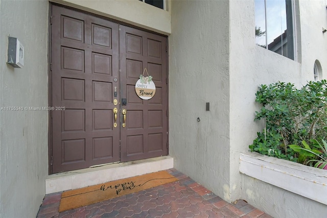 doorway to property featuring stucco siding