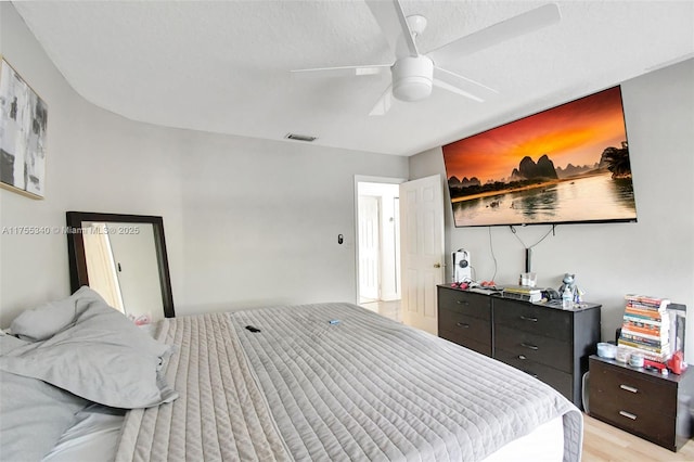 bedroom with a ceiling fan, visible vents, and light wood-style floors