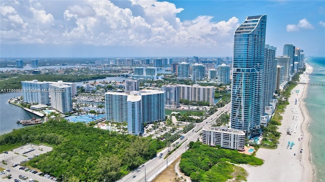 aerial view featuring a water view, a view of city, and a beach view