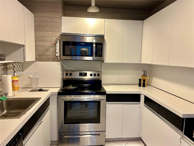 kitchen featuring light countertops, appliances with stainless steel finishes, a sink, and white cabinetry