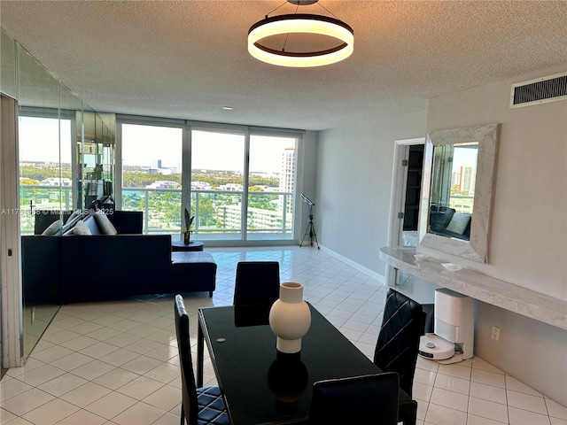 dining space featuring light tile patterned floors, a textured ceiling, visible vents, and a wealth of natural light