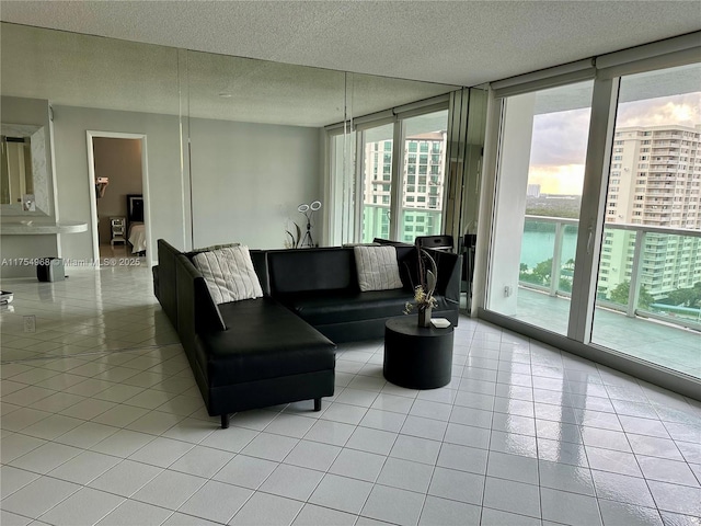 living area featuring light tile patterned floors, floor to ceiling windows, and a textured ceiling