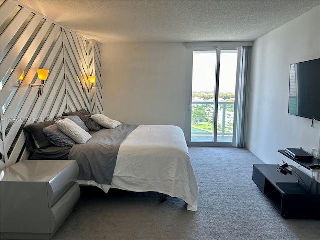 carpeted bedroom with access to outside and a textured ceiling