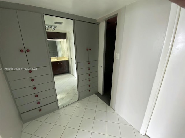 hallway with light tile patterned floors and a sink