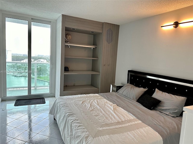 tiled bedroom featuring access to outside and a textured ceiling