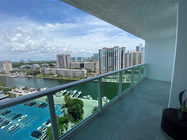 balcony with a water view and a view of city