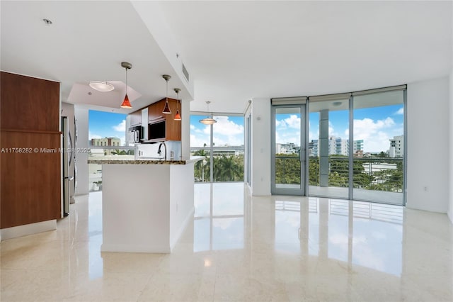 kitchen featuring appliances with stainless steel finishes, floor to ceiling windows, a city view, and dark stone countertops