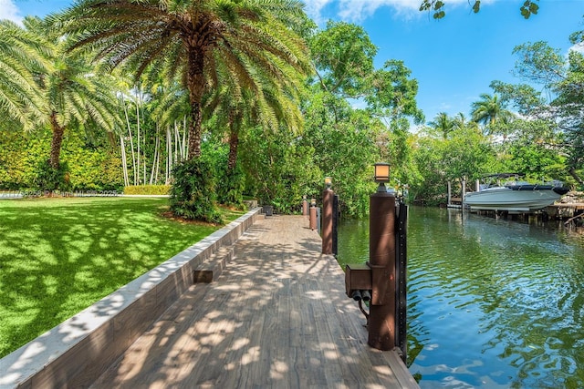 view of property's community featuring a yard, a dock, and a water view