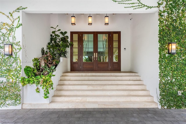 view of exterior entry with french doors and stucco siding