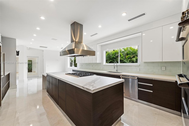 kitchen featuring dark brown cabinets, island exhaust hood, modern cabinets, and a sink