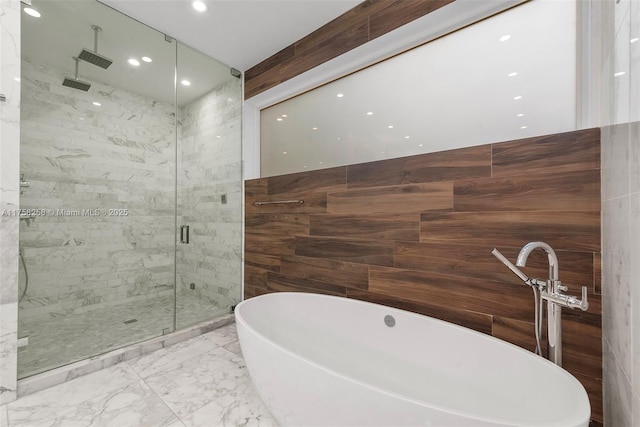 bathroom with a soaking tub, marble finish floor, and a shower stall