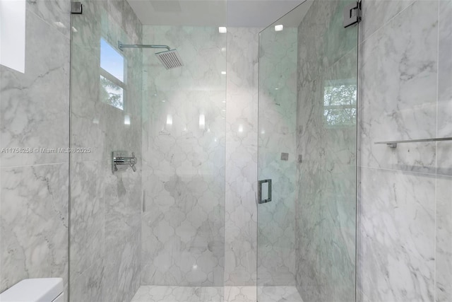 full bath featuring a marble finish shower and toilet