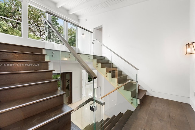 stairway featuring hardwood / wood-style flooring, wooden ceiling, and beam ceiling