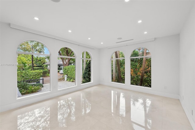 spare room featuring recessed lighting and baseboards