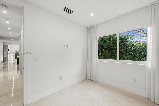 empty room featuring light tile patterned floors, recessed lighting, visible vents, and baseboards