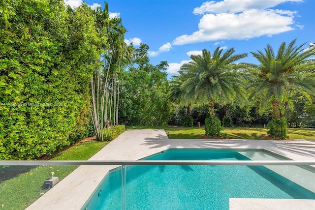 outdoor pool with a yard and a patio