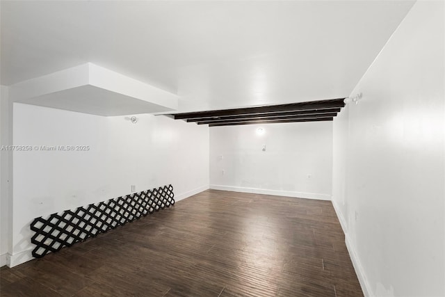 empty room featuring wood finished floors and baseboards