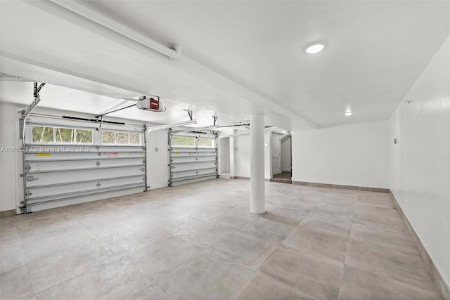 garage featuring a garage door opener and baseboards