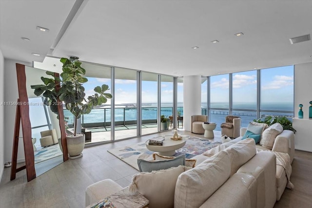 living area featuring a wall of windows, a water view, and a wealth of natural light