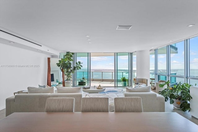 living room featuring a wall of windows and a water view