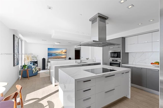 kitchen featuring island range hood, modern cabinets, appliances with stainless steel finishes, and backsplash