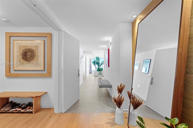 corridor with baseboards and wood finished floors