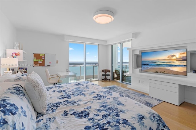 bedroom featuring access to exterior and wood finished floors