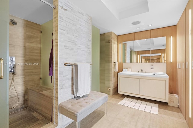 full bathroom featuring a stall shower, tile patterned flooring, a tray ceiling, and vanity