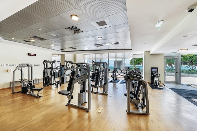 gym with visible vents, a wall of windows, and wood finished floors