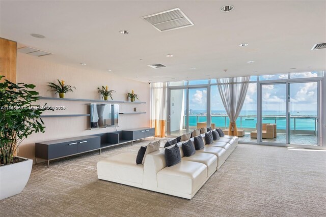 living area with carpet floors, a wall of windows, and visible vents