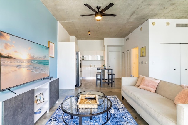 living room featuring finished concrete floors, visible vents, and a ceiling fan