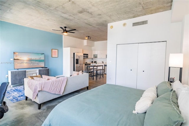 bedroom featuring ceiling fan, a closet, stainless steel fridge, and visible vents