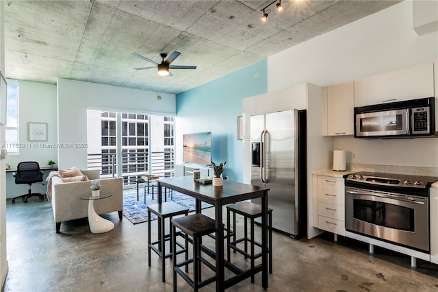 kitchen featuring ceiling fan, concrete floors, stainless steel appliances, and light countertops