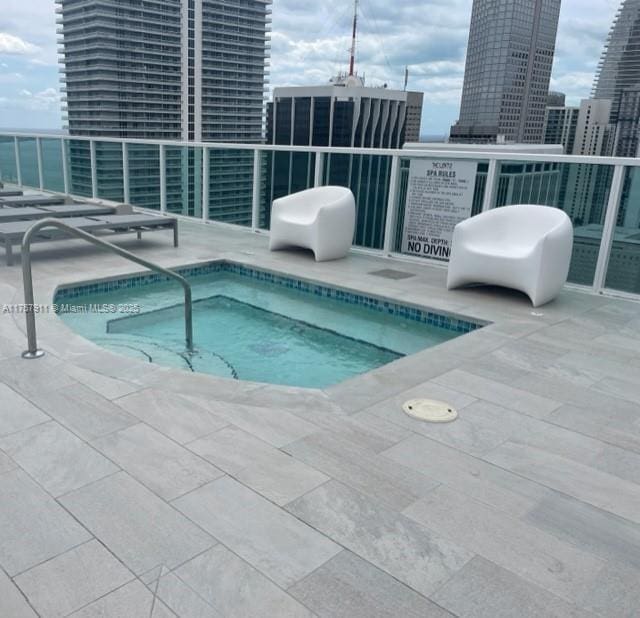 view of pool featuring a view of city and a community hot tub