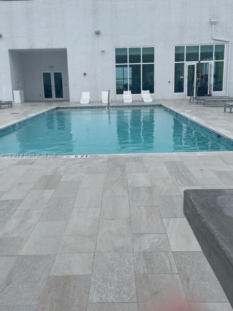 community pool featuring french doors and a patio