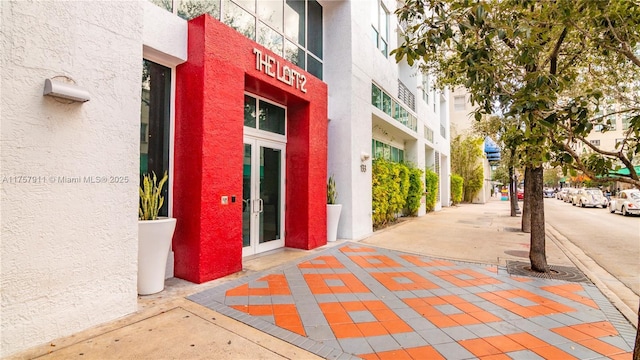 property entrance featuring french doors and stucco siding