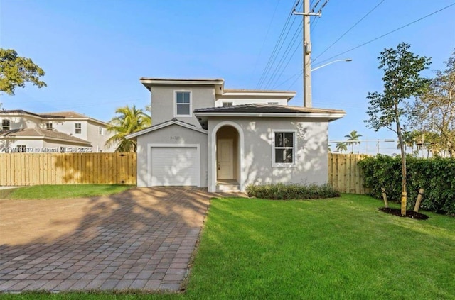 view of front of home with a garage, fence, decorative driveway, a front lawn, and stucco siding