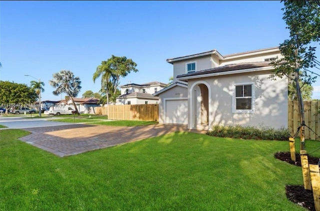 view of yard with a garage, decorative driveway, and fence