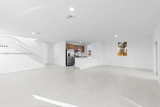 unfurnished living room with recessed lighting, visible vents, and a sink