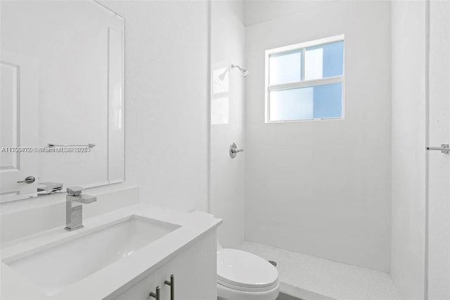 bathroom with toilet, a shower stall, and vanity