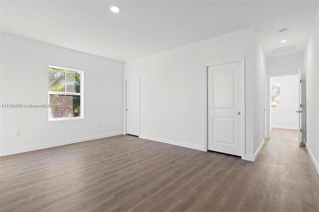 spare room featuring baseboards, dark wood-style flooring, and recessed lighting