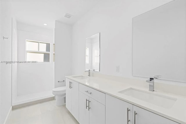 bathroom with toilet, double vanity, visible vents, and a sink