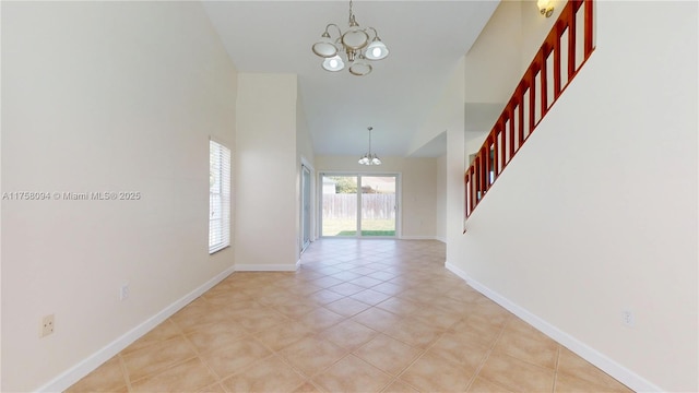 interior space with a chandelier, light tile patterned floors, and baseboards