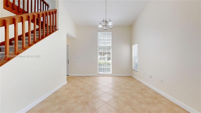 interior space with tile patterned floors, a notable chandelier, a high ceiling, and stairs