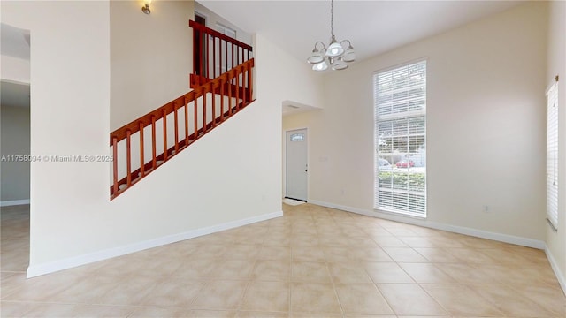 interior space with a wealth of natural light, stairway, a high ceiling, and baseboards