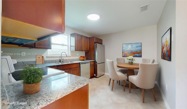 kitchen featuring visible vents, a sink, baseboards, appliances with stainless steel finishes, and light stone countertops